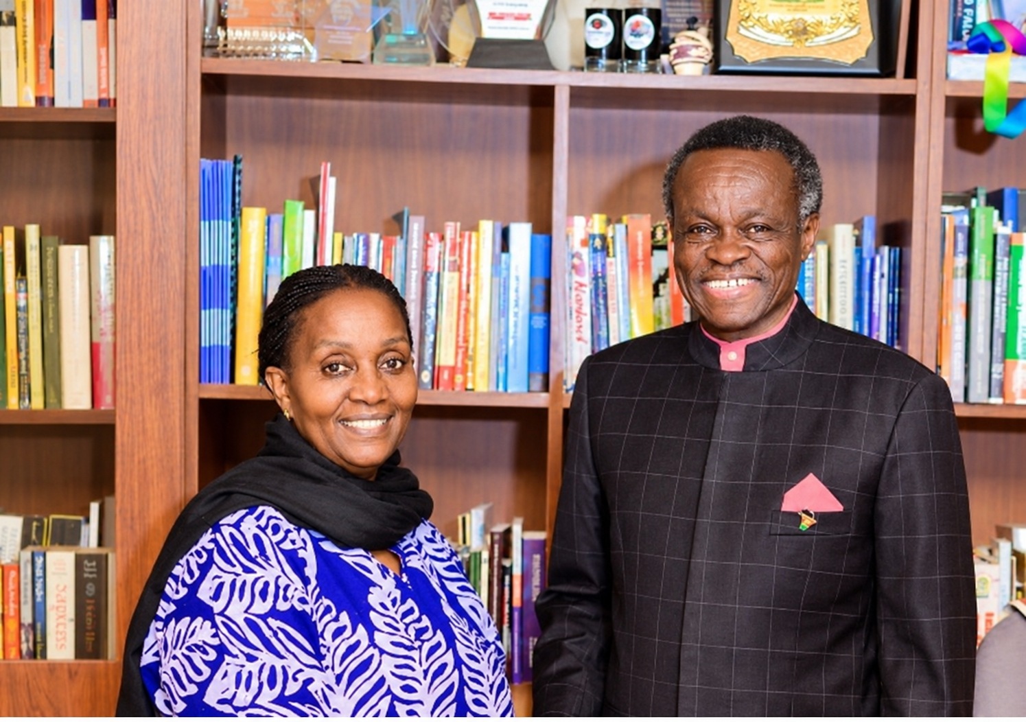 Rose Ssali and PLO Lumumba together in front of bookshelves