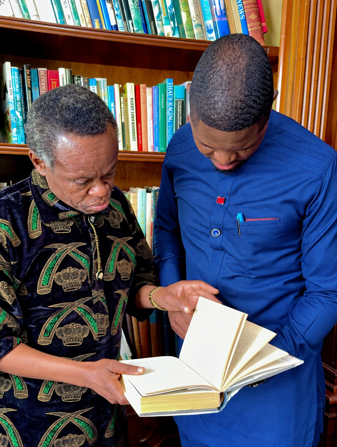 Shacky Timburwa and PLO Lumumba reading an open book together